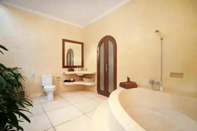 a bathroom with a tub and a toilet and a sink at Legian Blue Ocean Villa in Seminyak