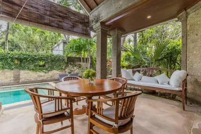 an outdoor patio with a table and chairs and a couch at Castila Saraswati - Tranquil 4BR Villa in Kayu Aya in Seminyak