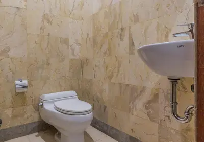 a bathroom with a toilet and a sink at Castila Saraswati - Tranquil 4BR Villa in Kayu Aya in Seminyak