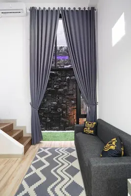 a living room with a couch and a window at Mezzanine Luxury Smart Room - Sanur in Sanur
