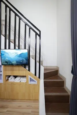 a living room with a staircase with a television at Mezzanine Luxury Smart Room - Sanur in Sanur