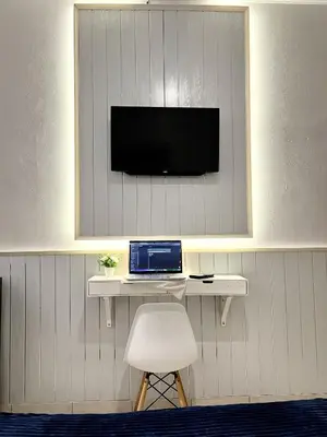 a room with a desk with a laptop and a chair at Thapleuk Residence in Nusa Dua