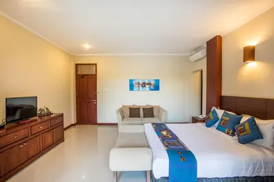 a bedroom with a large bed and a television at Villa Tantri in Kerobokan