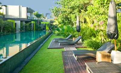a resort with a swimming pool with lounge chairs and a swimming pool at Cicada Luxury Townhouses in Seminyak