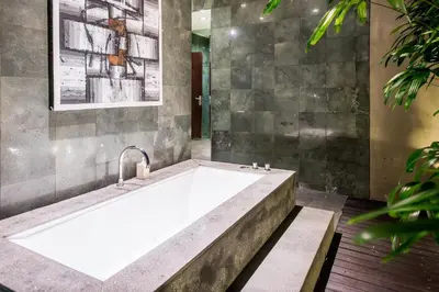 a bathroom with a large bath tub with a faucet at Cicada Luxury Townhouses in Seminyak