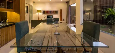 a dining table with a wine glass on top of it at Cicada Luxury Townhouses in Seminyak