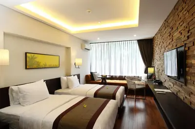 a hotel room with two beds and a television at Watermark Hotel & Spa Bali in Jimbaran