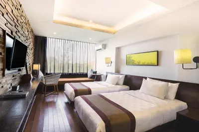 a hotel room with two beds and a flat screen tv at Watermark Hotel & Spa Bali in Jimbaran