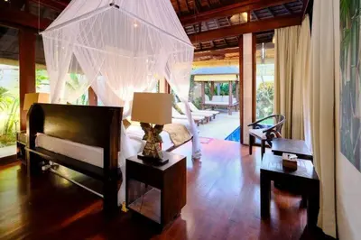 a bedroom with a bed and a lamp in a room at Villa Jepun Seminyak in Canggu