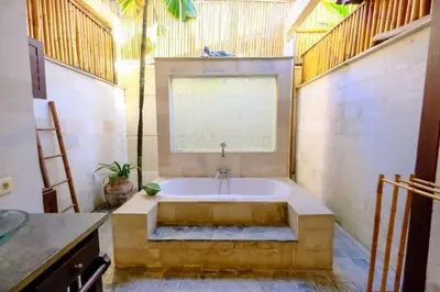 a bathroom with a bath tub with a window at Villa Jepun Seminyak in Canggu