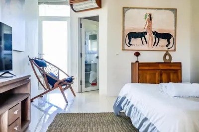 a bedroom with a bed and a picture of horses at Canggu Art Loft - Luxury Stay with Berawa View 2BDR in Canggu