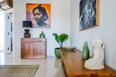 a living room with a table with a statue on it at Canggu Art Loft - Luxury Stay with Berawa View 2BDR in Canggu