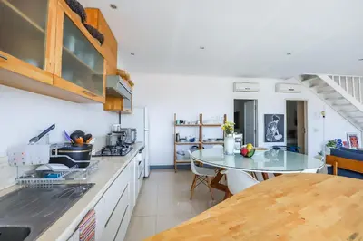 a kitchen with a table and a counter top at Canggu Art Loft - Luxury Stay with Berawa View 2BDR in Canggu