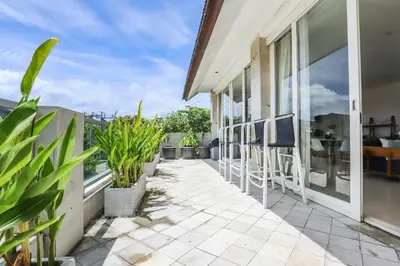 a balcony with chairs and plants on a house at Canggu Art Loft - Luxury Stay with Berawa View 2BDR in Canggu