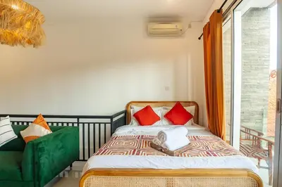 a bedroom with a bed and a green couch at Central Cozy Villa 3BR 5min walk to shops, beach in Legian