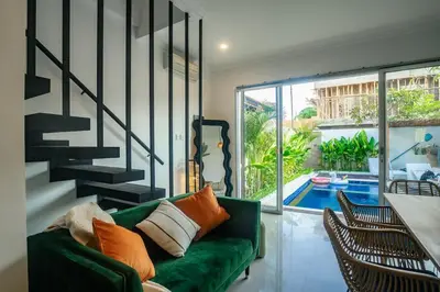 a living room with a green couch and a swimming pool at Central Cozy Villa 3BR 5min walk to shops, beach in Legian