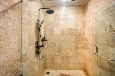 a bathroom with a shower with a glass door at Central Cozy Villa 3BR 5min walk to shops, beach in Legian