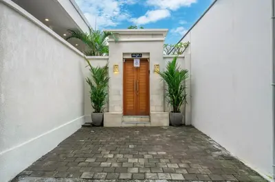 a entrance to a white building with a brown door at Balibay 3 - Luxurious Private Villa with Pool, Just Minutes from the City Center! in Seminyak