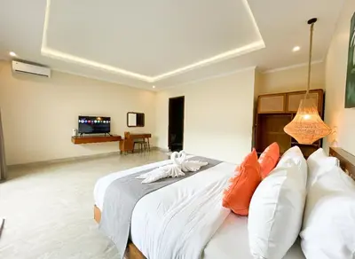 a bedroom with a large bed with orange and white pillows at Villa Sinergi Seminyak 6 in Seminyak