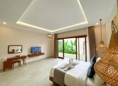a bedroom with a bed and a desk and a television at Villa Sinergi Seminyak 6 in Seminyak