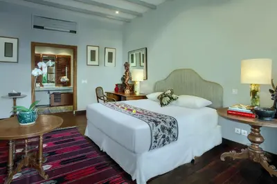a bedroom with a large white bed and a table at Room & Vespa 3 - Relaxing Stay Center Seminyak in Seminyak