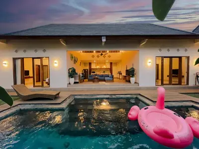 a pool with a pink inflatable pig in front of a house at Villa Sinergi Seminyak 5 in Seminyak
