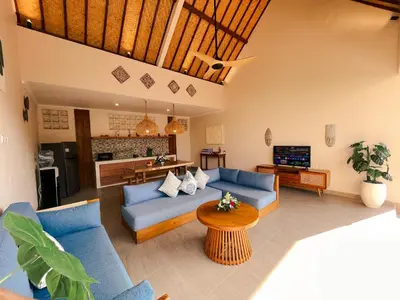 a living room with blue couches and a kitchen at Villa Sinergi Seminyak 5 in Seminyak