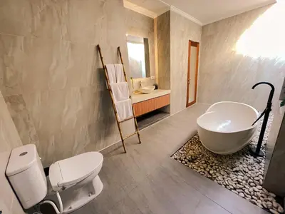 a bathroom with a tub and a toilet and a sink at Villa Sinergi Seminyak 5 in Seminyak