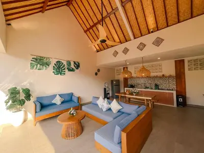 a living room with blue couches and a kitchen at Villa Sinergi Seminyak 5 in Seminyak