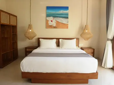 a bedroom with a bed and two pendant lights at Villa Sinergi Seminyak 5 in Seminyak