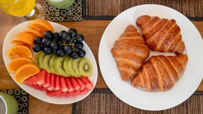 two plates of bread and fruit on a table at Villa Anjali Blue by Villa Finder in Seminyak
