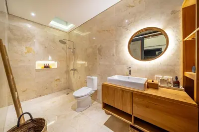 a bathroom with a sink and a toilet and a mirror at Lekatica- 2BR Paradise Villa with Expansive Pool in Seminyak