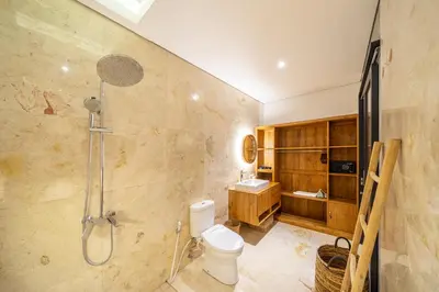 a bathroom with a shower and a toilet and a sink at Lekatica- 2BR Paradise Villa with Expansive Pool in Seminyak