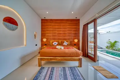 a bedroom with a bed with a wooden headboard at 3 Bed Cozy Mediterranean-Style Escape in Berawa in Canggu