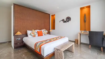 a bedroom with a large bed with a wooden headboard at Villa Anjali Orange by Villa Finder in Seminyak