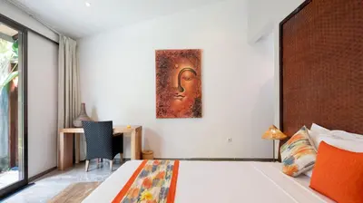 a bedroom with a bed and a painting on the wall at Villa Anjali Orange by Villa Finder in Seminyak