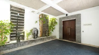 an empty room with a door and plants on the wall at Villa Anjali Green by Villa Finder in Seminyak