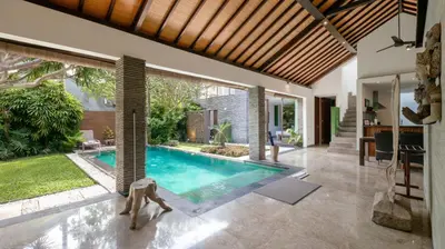 a swimming pool in the middle of a house at Villa Anjali Green by Villa Finder in Seminyak