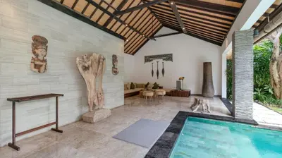 a villa with a swimming pool and a living room at Villa Anjali Green by Villa Finder in Seminyak