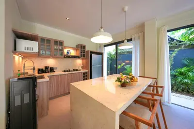 a kitchen with a large island in the middle at Twin Villas Cora & Zeno by Exotic Bali Properties in Seminyak