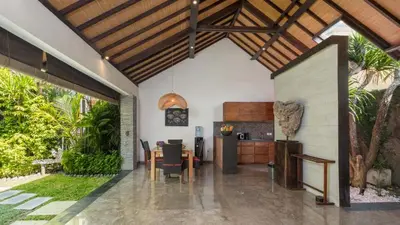 an open kitchen and dining room of a house at Villa Anjali Purple by Villa Finder in Seminyak