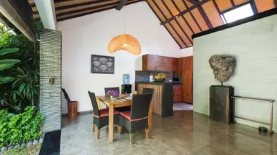 a dining room with a table and chairs at Villa Anjali Purple by Villa Finder in Seminyak