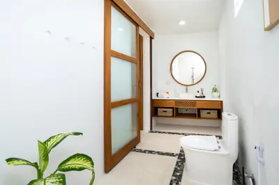 a bathroom with a toilet and a mirror at Villa Mandara Double Six in Legian