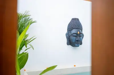 a buddha head on a wall next to a plant at Villa Mandara Double Six in Legian