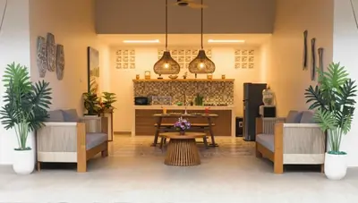 a lobby with chairs and a table and a kitchen at Villa Sinergi Seminyak 4 in Seminyak