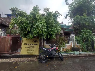 a motorcycle parked next to a house for rent sign at Villa Yoni in Bali in Pesanggaran