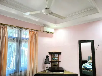 a bedroom with a ceiling fan and a mirror at Villa Yoni in Bali in Pesanggaran
