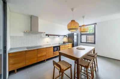 a kitchen with a wooden table and some chairs at Casa Nadi in Seminyak