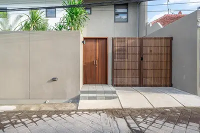 a house with a wooden door on the side of it at Casa Nadi in Seminyak