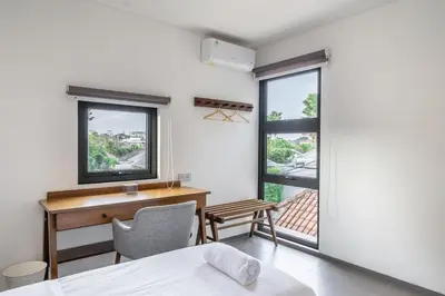 a bedroom with a desk and a chair and window at Casa Nadi in Seminyak